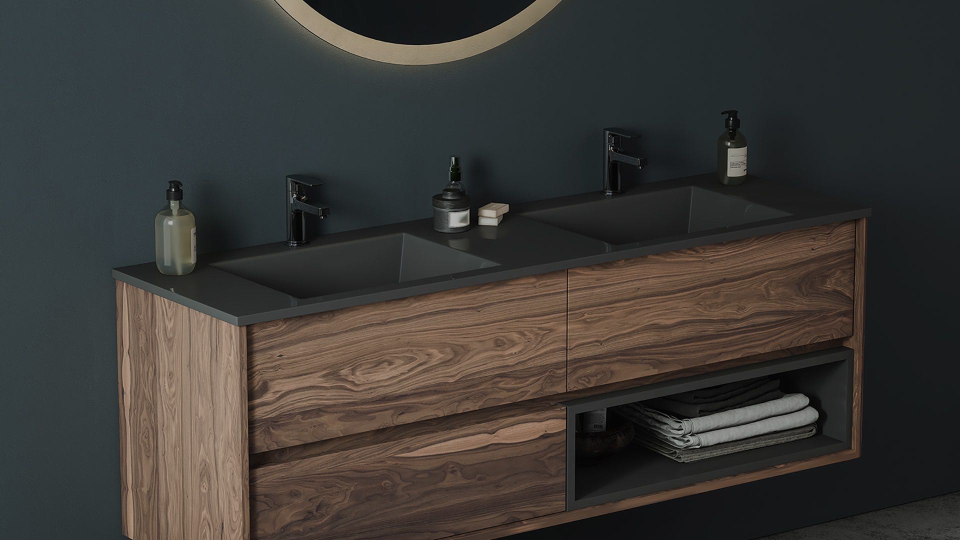 Floating walnut double vanity with a dark countertop and a round mirror