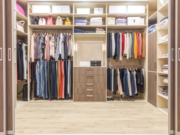 Walk-in closet with full-height hanging, shelves and a central drawer unit