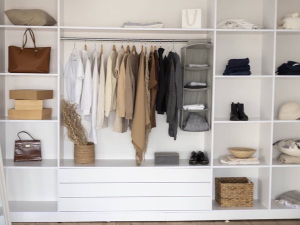 White reach-in closet with hanging rails, open shelves and drawers