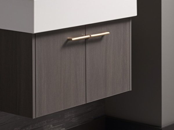 Close-up of a dark wood cabinet with brass handles