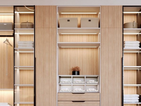 Oak wardrobe with lit open shelves and stacked towels