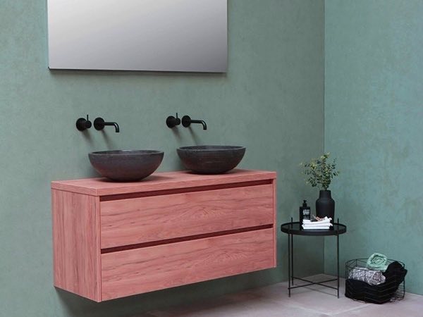 Rose wood double vanity with black vessel basins on a teal wall