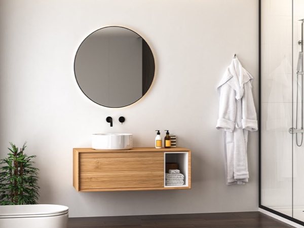 Small oak floating vanity with a round mirror